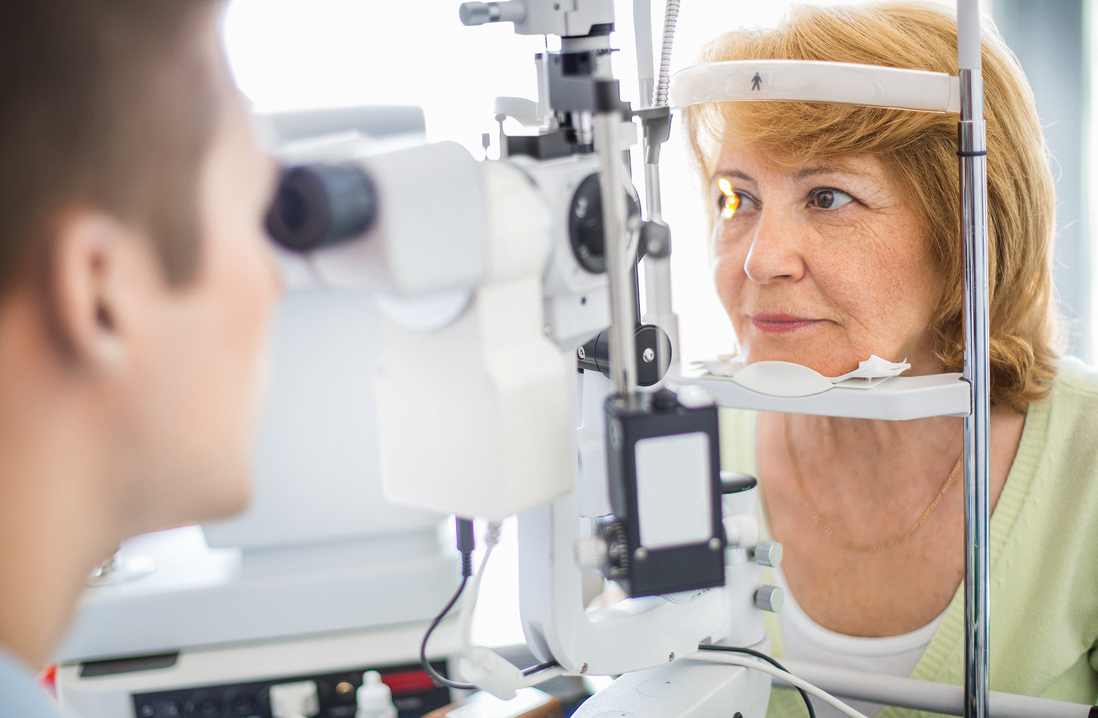 A optometrist is testing eyes of a woman